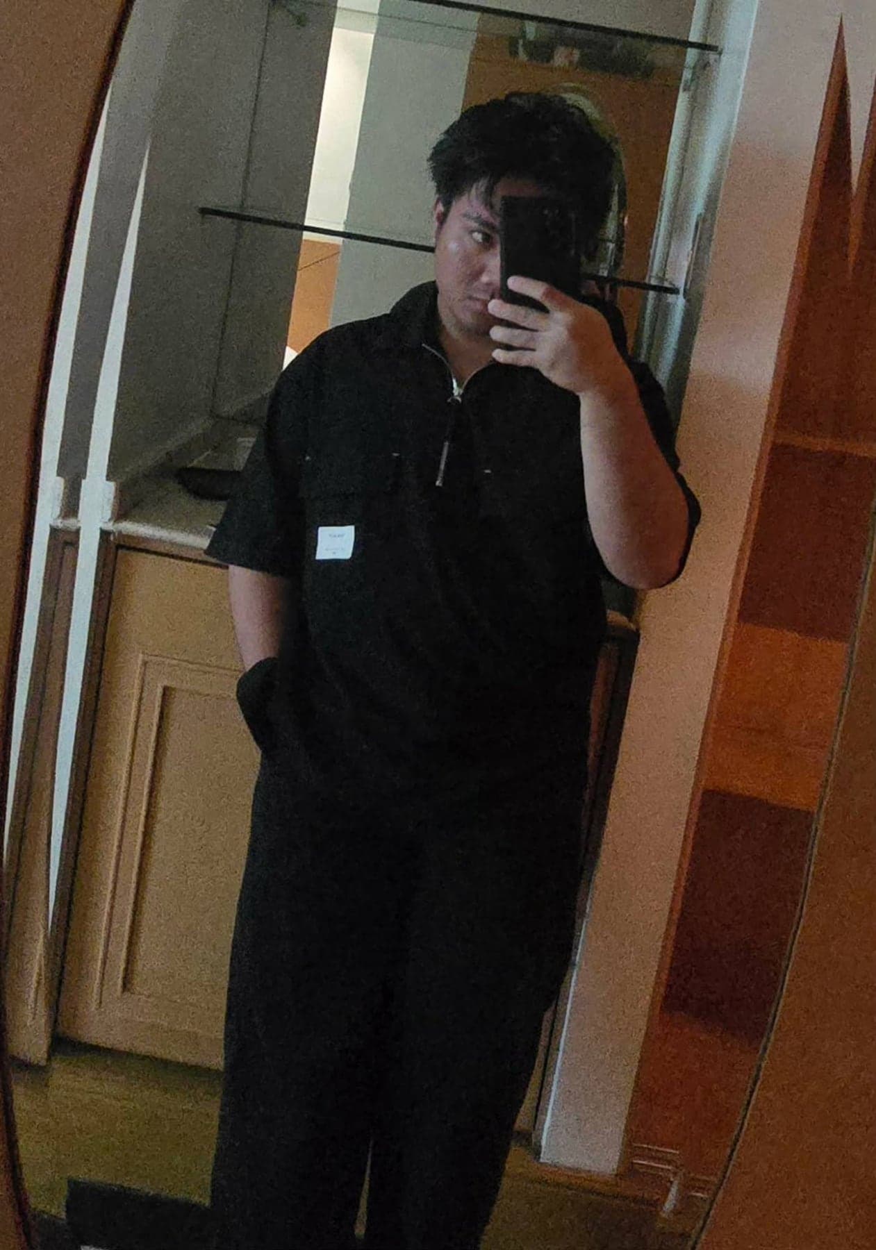 Me, taking a mirror selfie in an all-black outfit, phone partly covering my face
